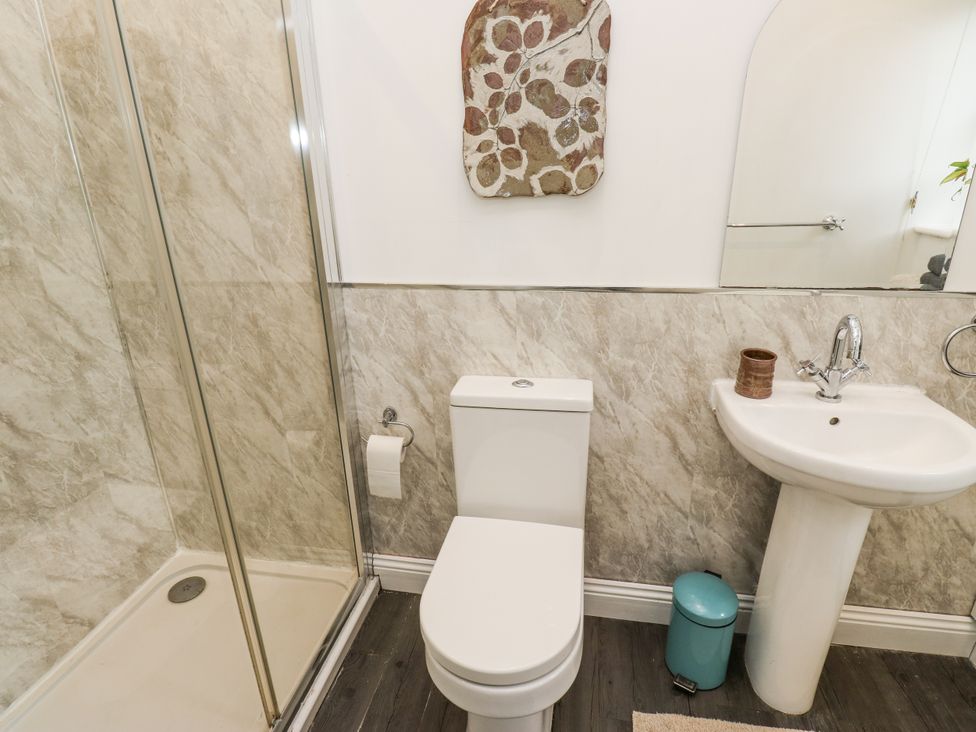 A bathroom with a shower, toilet, and sink at The Treetop