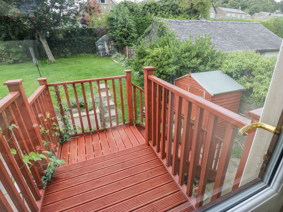 A garden view with decking and a shed at The Treetop 