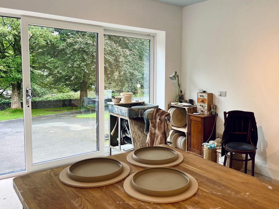 A workshop with a table, plates, and a chair at The Treetop in Giggleswick near Settle