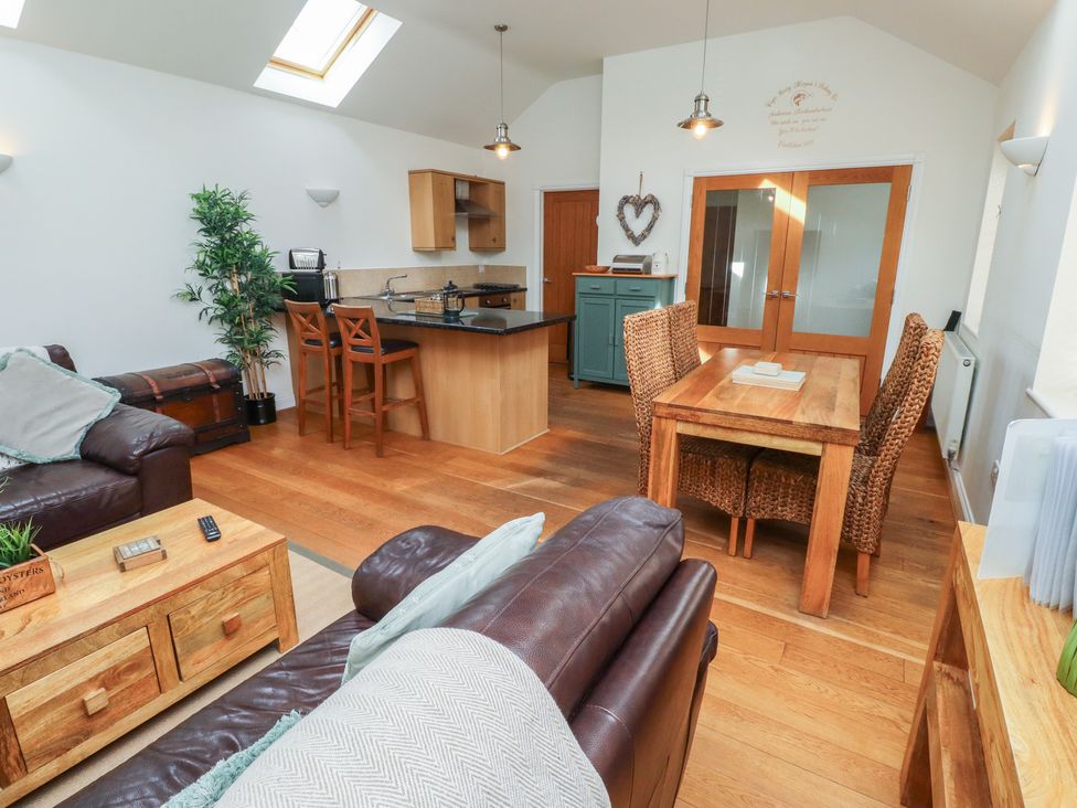 A living area with a sofa and dining space at Hideaway Cottage No 1, Seahouses