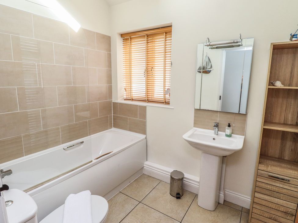A bathroom with a bathtub and sink at Hideaway Cottage No 1 Seahouses