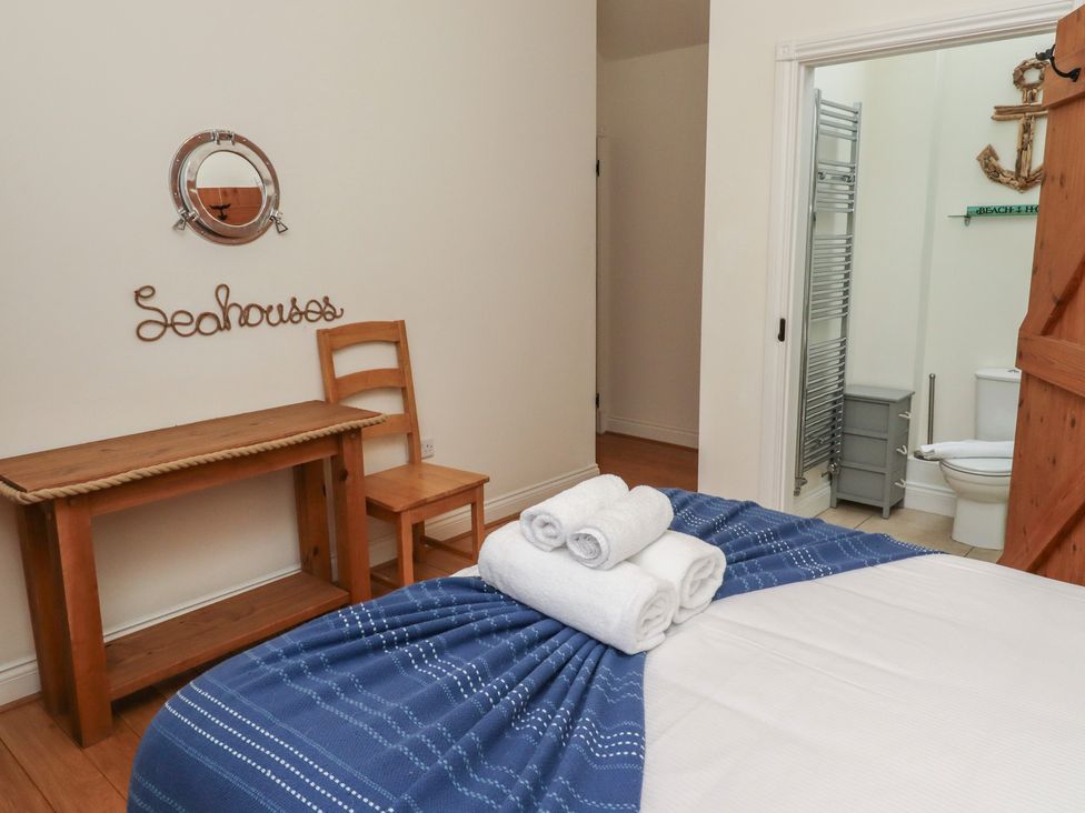 A bedroom with a bed and a desk at Hideaway Cottage No 1 Seahouses