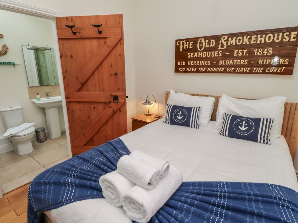A bedroom with a bed and an en suite bathroom at The Old Smokehouse in Seahouses