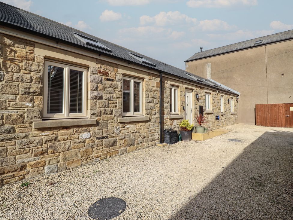 An outdoor area with a stone building and gravel surface at Hideaway Cottage No 1 Seahouses