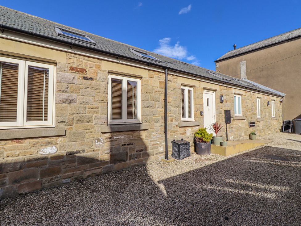 An outdoor area with stone walls and gravel at Hideaway Cottage No 1 in Seahouses