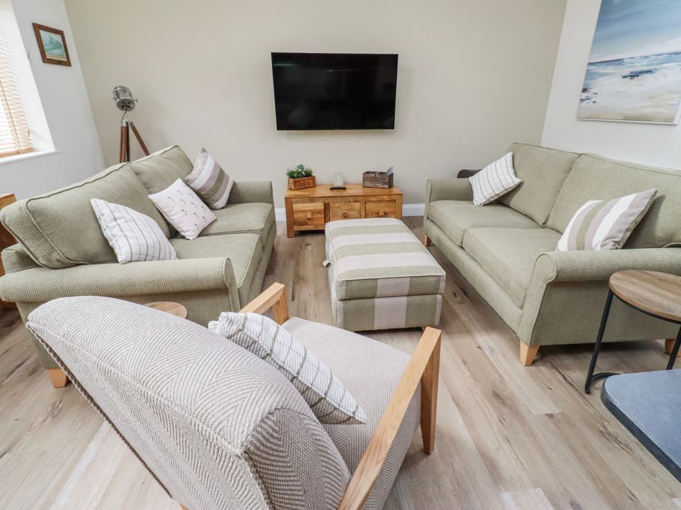 A living room with sofas and a television at Hideaway Cottage No 1 in Seahouses