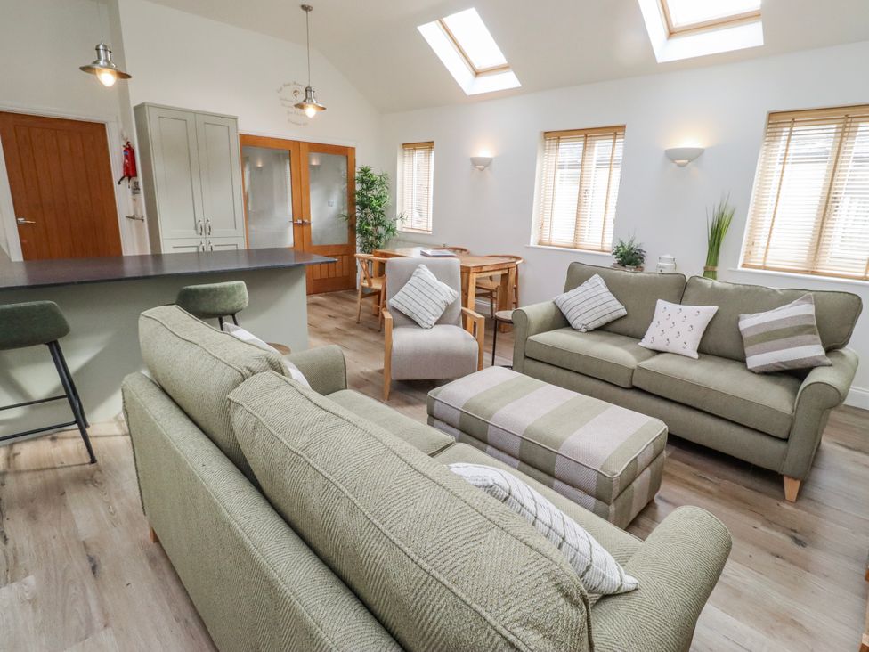 A living room with sofas and a dining table at Hideaway Cottage No 1 Seahouses