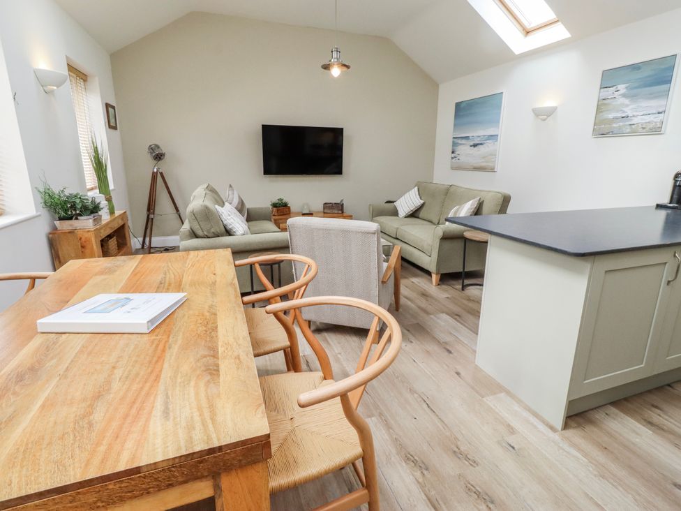 A living room with a television and sofa at Hideaway Cottage No 1 Seahouses