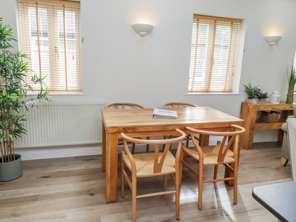 A dining room with a wooden table and chairs at Hideaway Cottage No 1 Seahouses