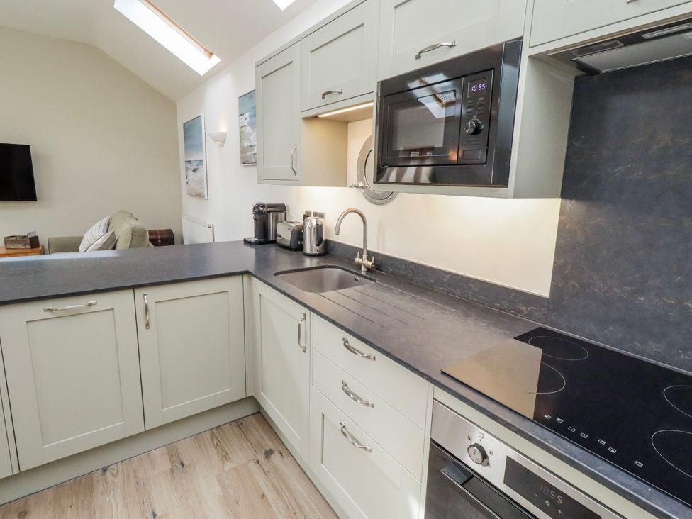A kitchen with a sink and microwave at Hideaway Cottage No 1 Seahouses