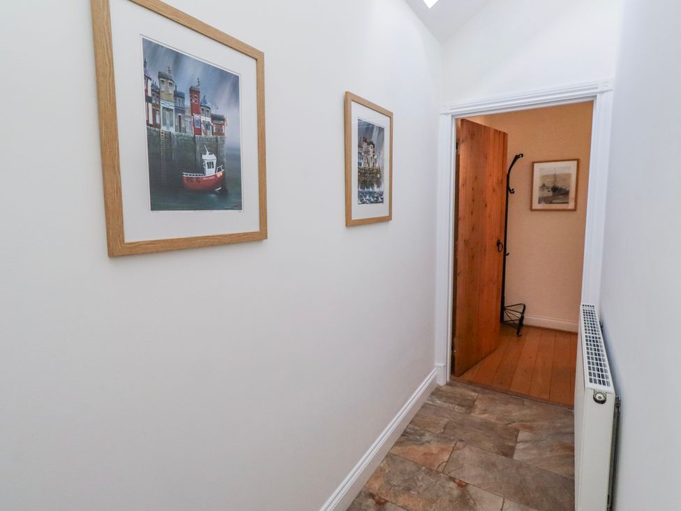A hallway with photographs on the wall at Hideaway Cottage No 1 Seahouses