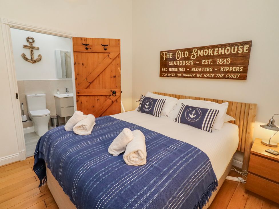 A bedroom with a bed and en suite bathroom at Hideaway Cottage No 1 Seahouses