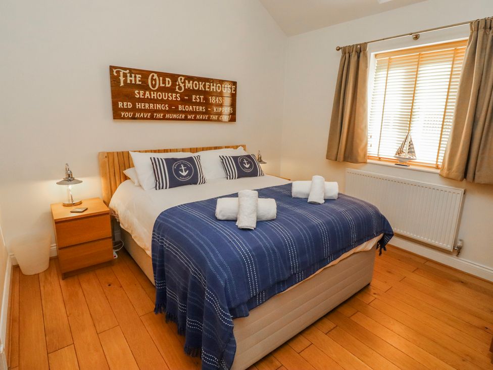 A bedroom with a bed and nightstand at Hideaway Cottage No 1 in Seahouses