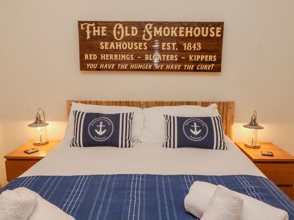 A bedroom with a bed and decorative pillows at The Old Smokehouse in Seahouses