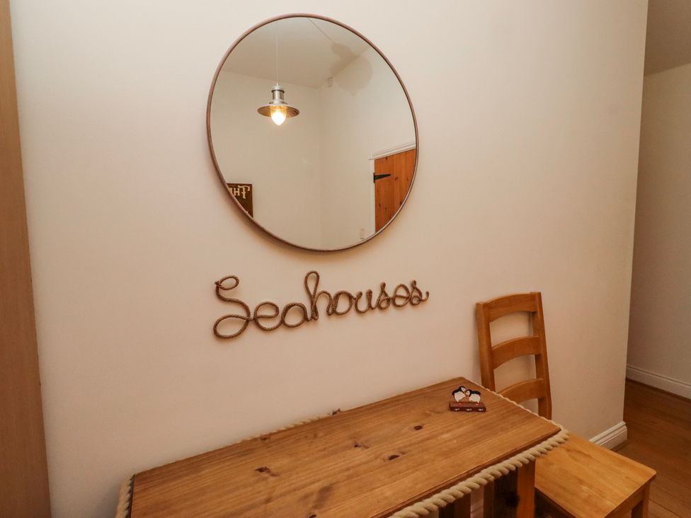 A dining room with a wooden table and chairs at Hideaway Cottage No 1 Seahouses