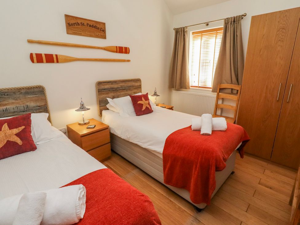 A bedroom with two beds and decorative paddles at Hideaway Cottage No 1 Seahouses