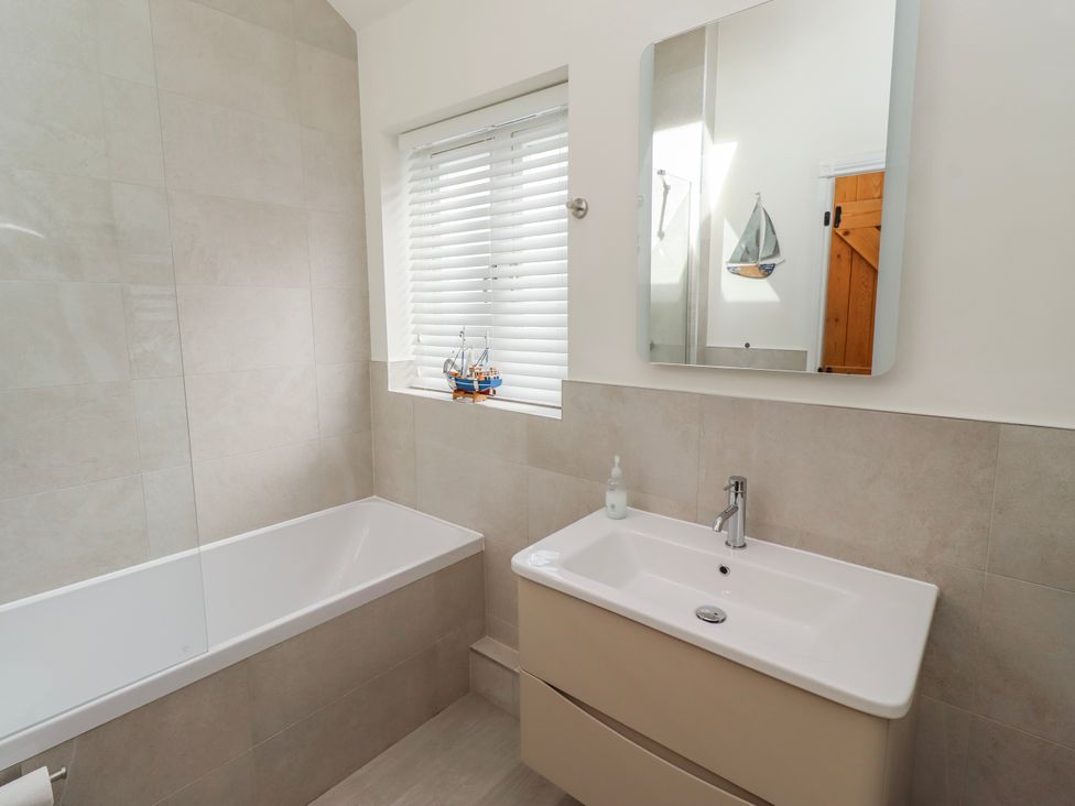 A bathroom with a bathtub and sink at Hideaway Cottage No 1 in Seahouses