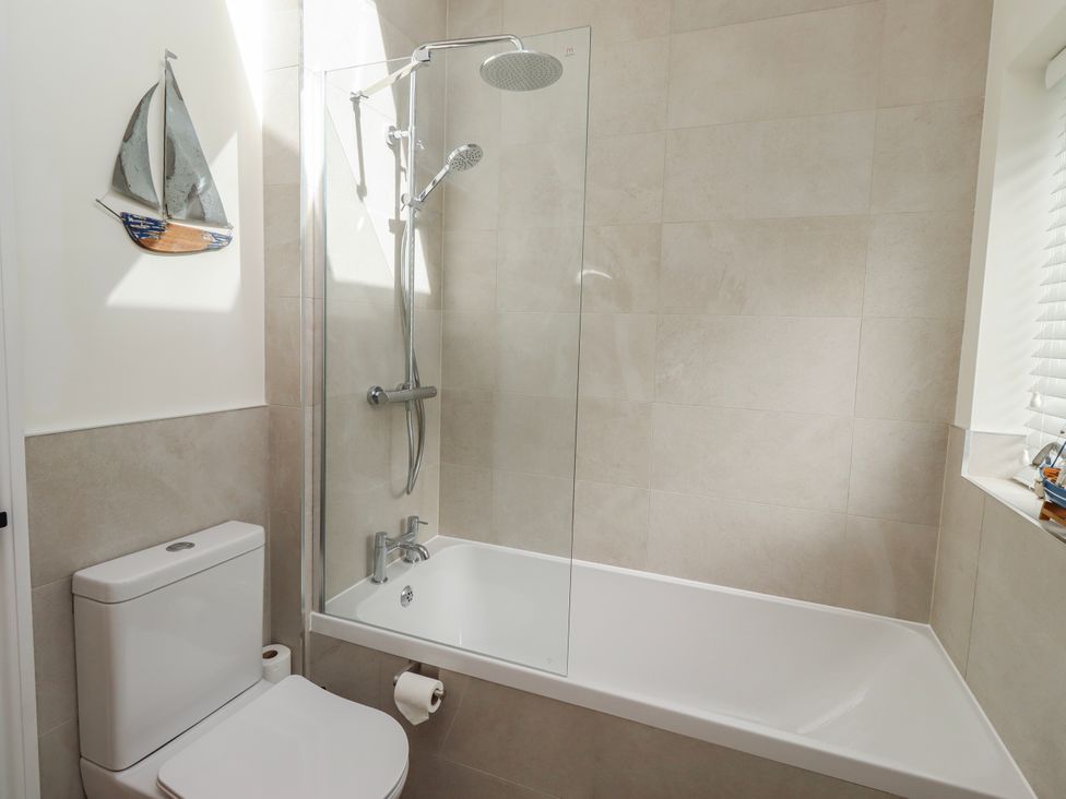 A bathroom with a bathtub and shower at Hideaway Cottage No 1 Seahouses