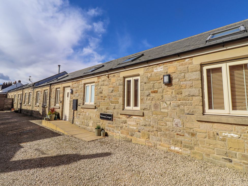 A stone building with windows and a sign at Hideaway Cottage No 1 Seahouses