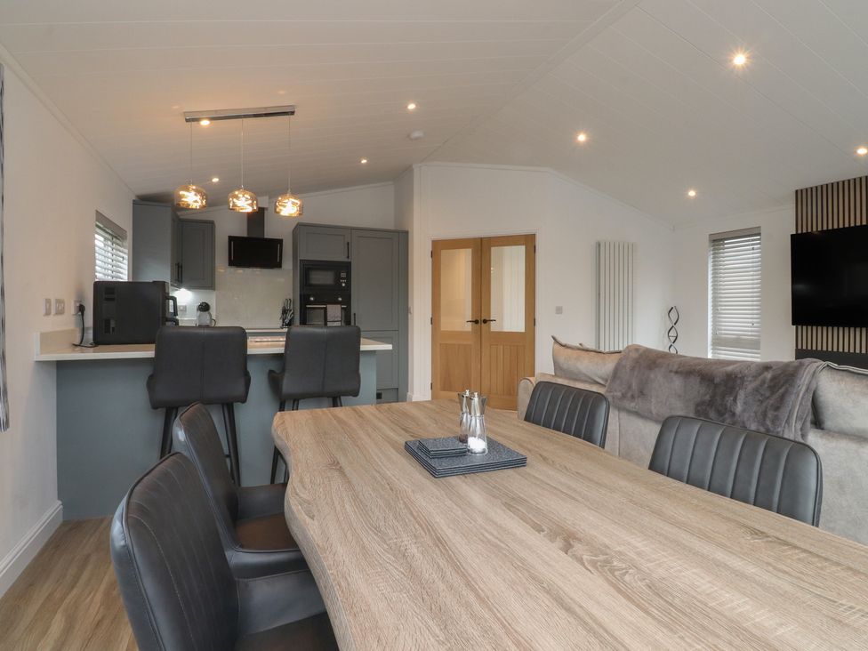 A dining room with a table and kitchen area at Number 35