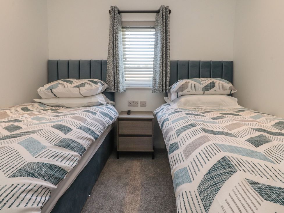 A bedroom with two beds and a nightstand at Number 35