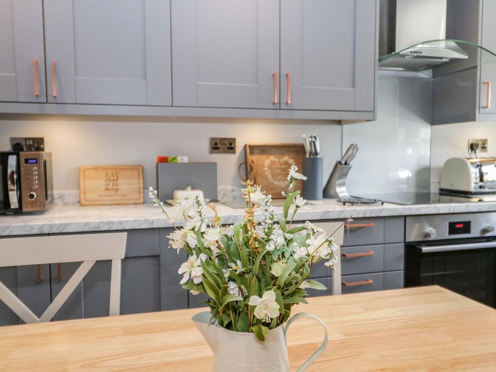 A kitchen with cabinets and appliances at Dolly Blue Backbarrow near Newby Bridge
