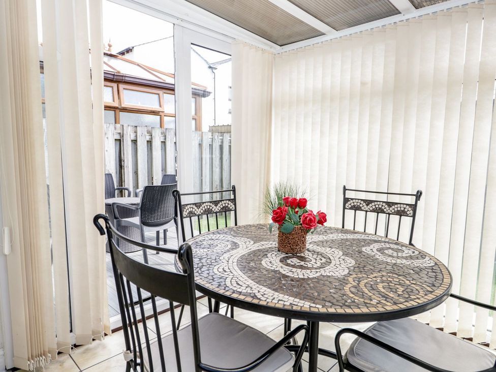 A table with chairs and a flower vase at Dolly Blue in Backbarrow near Newby Bridge