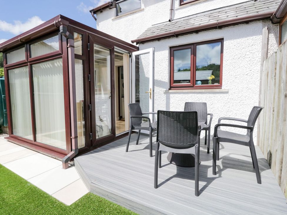 A garden area with chairs and a table at Dolly Blue Backbarrow near Newby Bridge