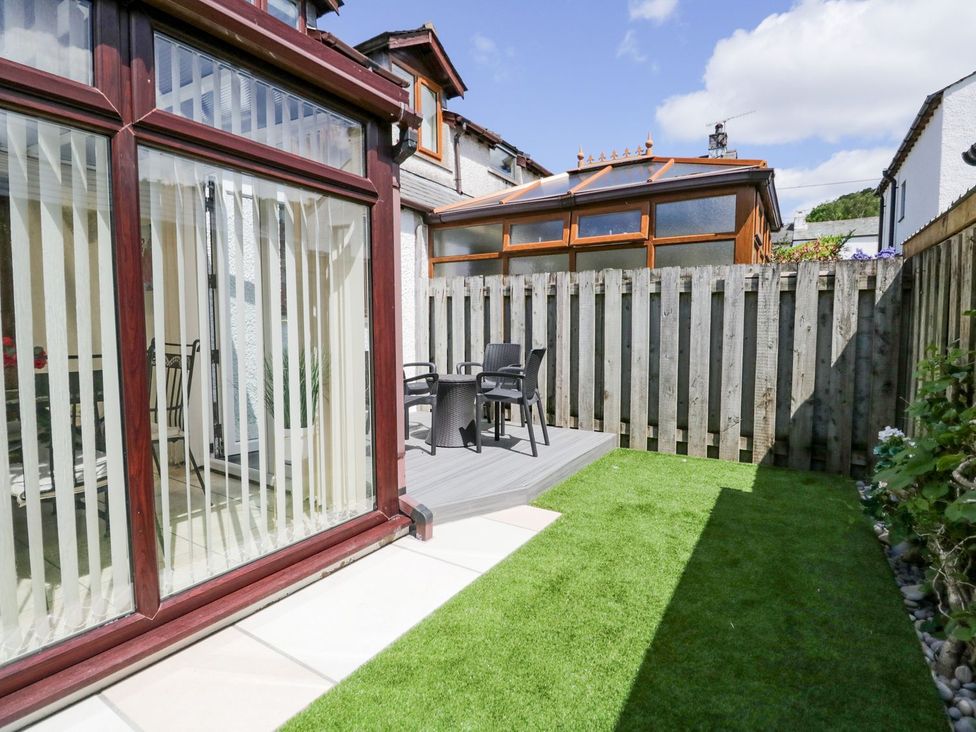 A garden with decking and chairs at Dolly Blue in Backbarrow near Newby Bridge