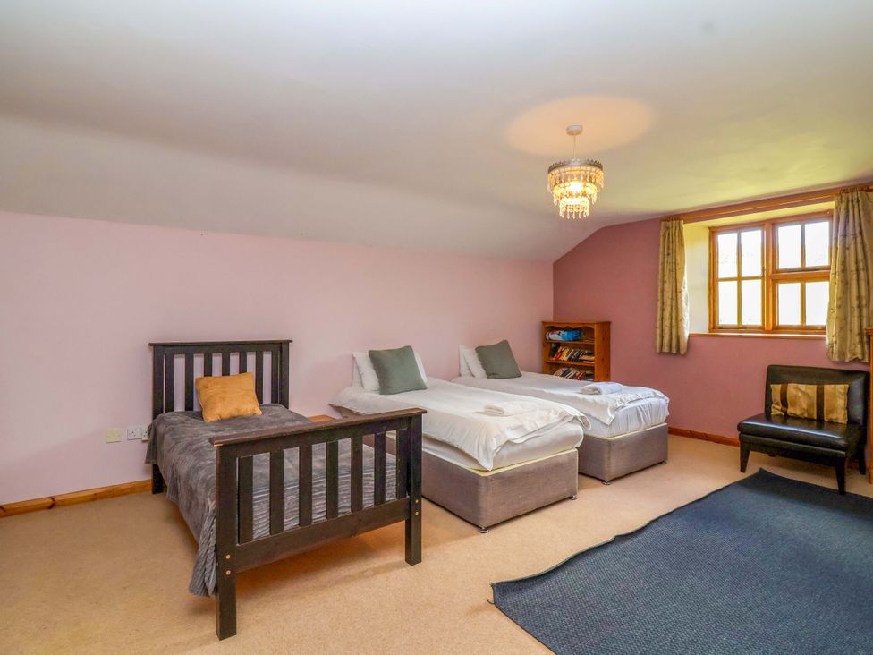 A bedroom with two single beds and a bookshelf at Millbarn in Crowcombe