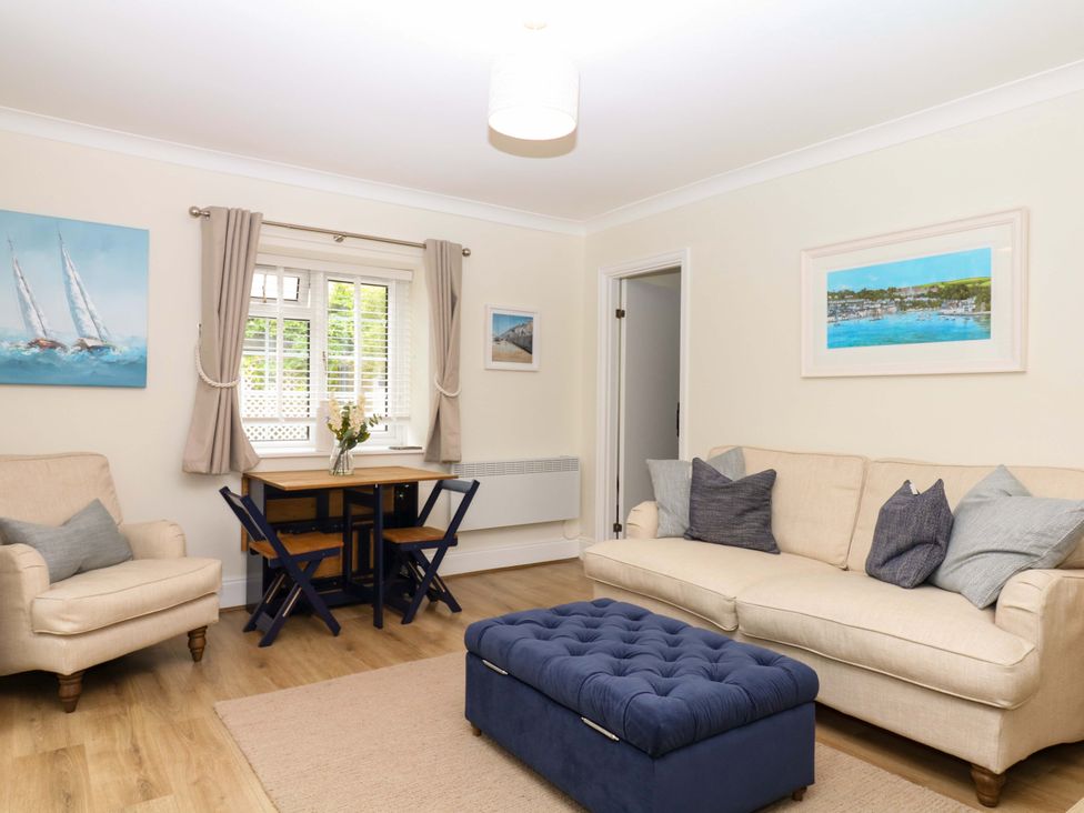 A living room with a sofa, armchair, and dining table at 2 Sheplegh Court in Blackawton near Dartmouth