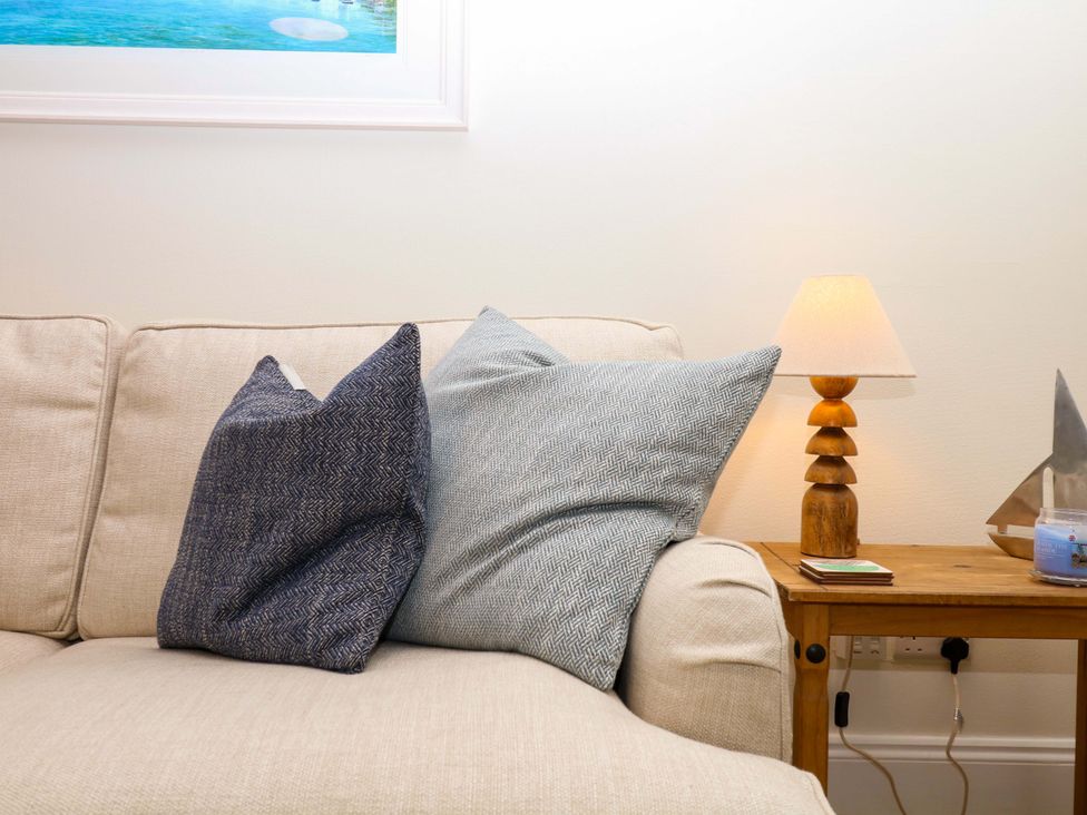 A living room with cushions on a sofa and a lamp on a side table at 2 Sheplegh Court Blackawton near Dartmouth