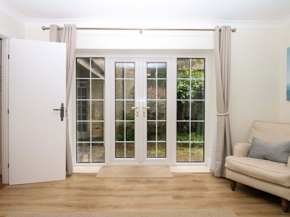 A living room with double doors and a sofa at 2 Sheplegh Court in Blackawton near Dartmouth
