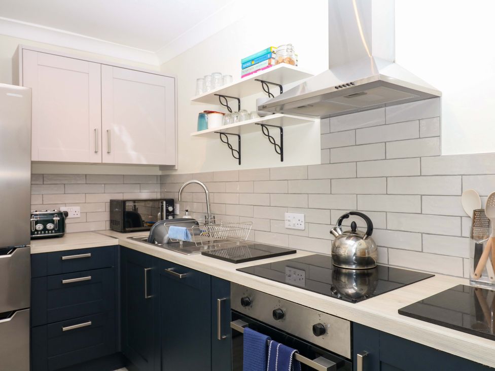 A kitchen with cabinets, stove, sink and appliances at 2 Sheplegh Court in Blackawton near Dartmouth