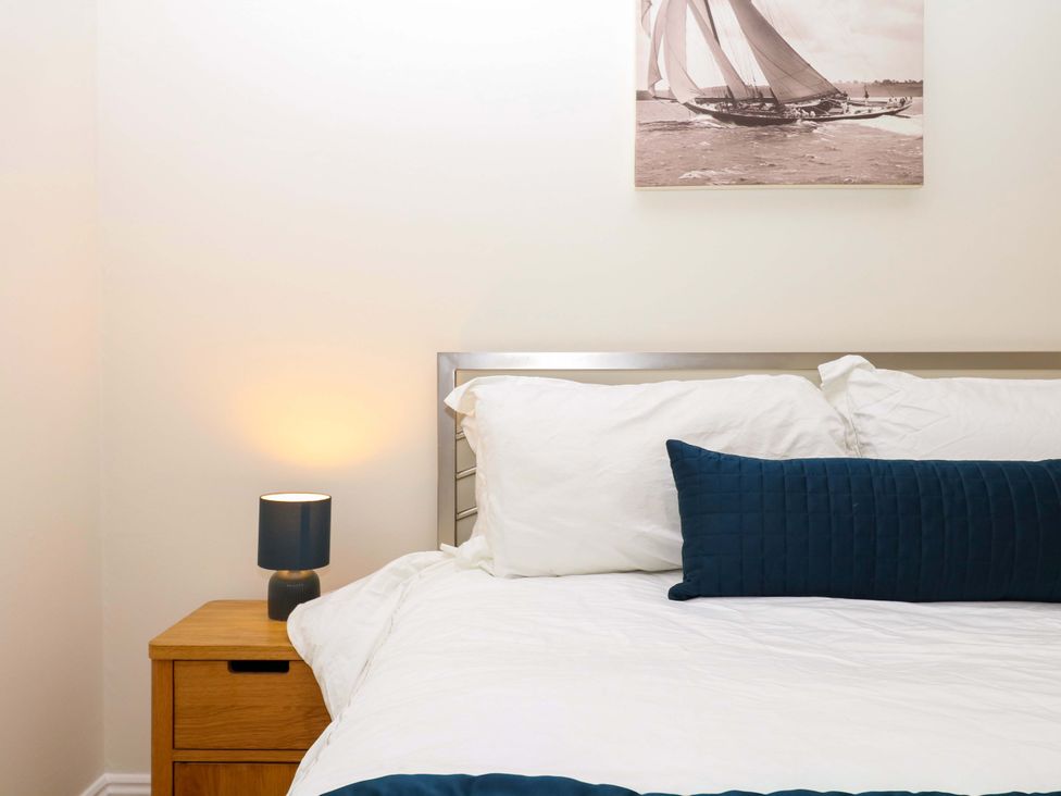 A bedroom with a bed and bedside table at 2 Sheplegh Court in Blackawton near Dartmouth