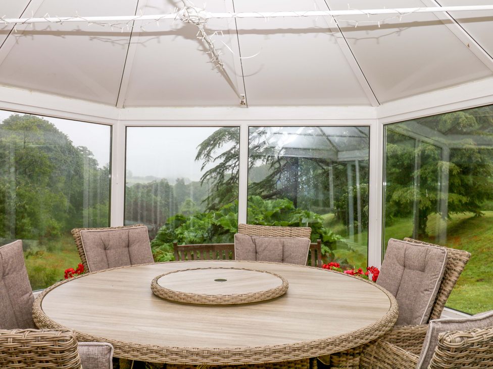 A conservatory with a round table and chairs at 2 Sheplegh Court Blackawton near Dartmouth