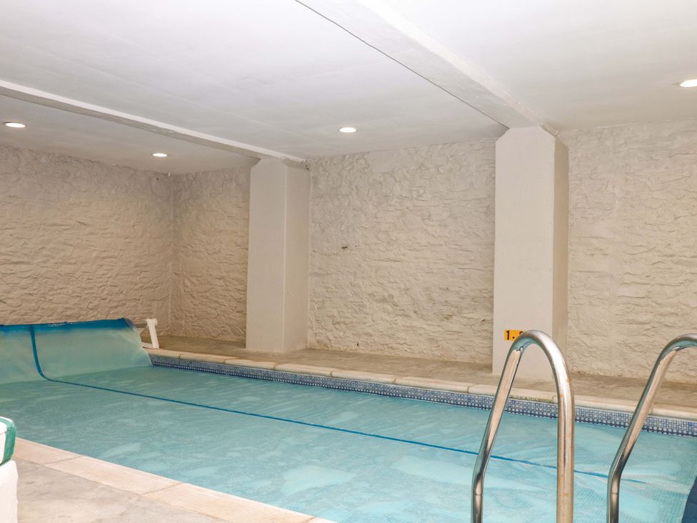 An indoor pool with a cover and ladder at 2 Sheplegh Court in Blackawton near Dartmouth