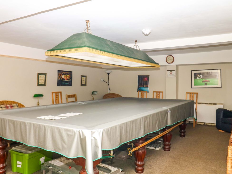A game room with a billiard table under a light fixture at 2 Sheplegh Court in Blackawton near Dartmouth