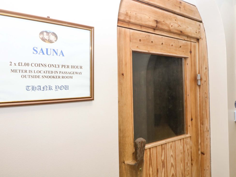 A sauna entrance with a wooden door and a sign at 2 Sheplegh Court Blackawton near Dartmouth