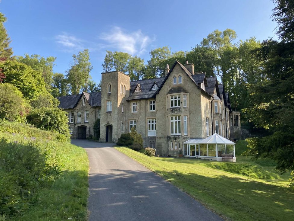 A large house with a driveway and garden at 2 Sheplegh Court in Blackawton near Dartmouth