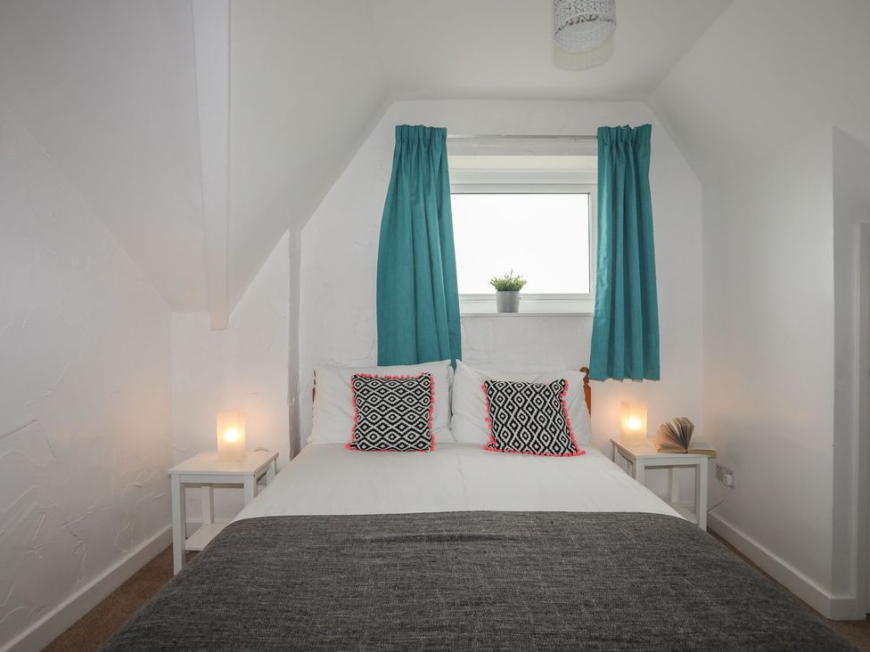A bedroom with a bed and nightstands at Fadrun - 3 Ty'n Don