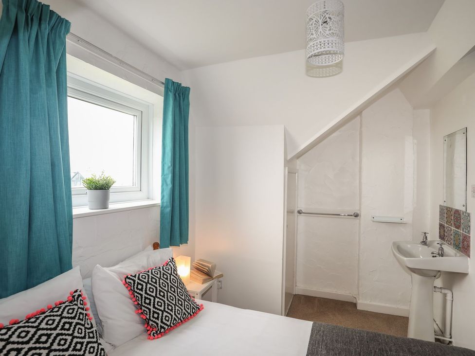 A bedroom with a bed and washbasin at Fadrun - 3 Ty'n Don