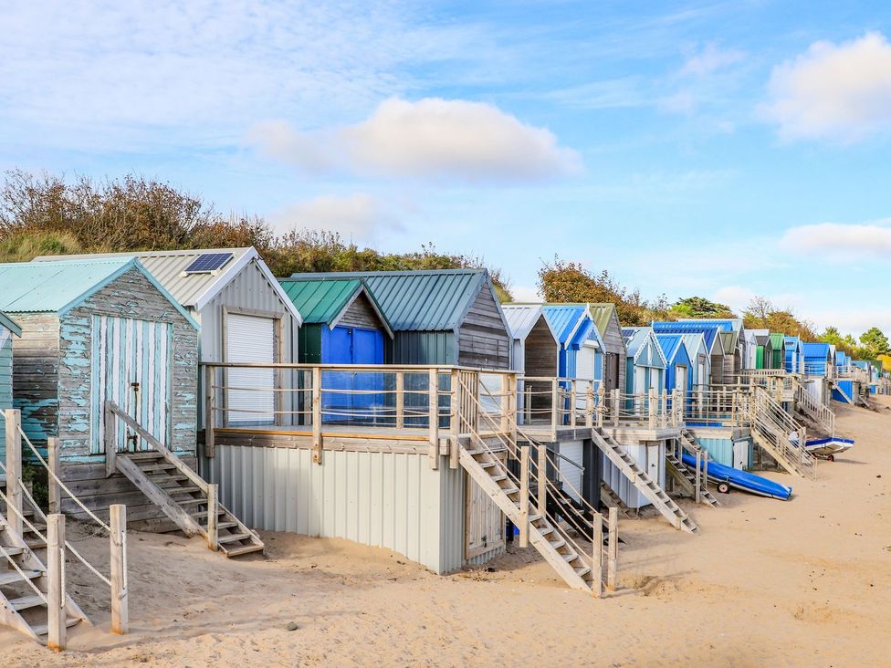 A row of beach huts on sand with stairs at Fadrun - 3 Ty'n Don 