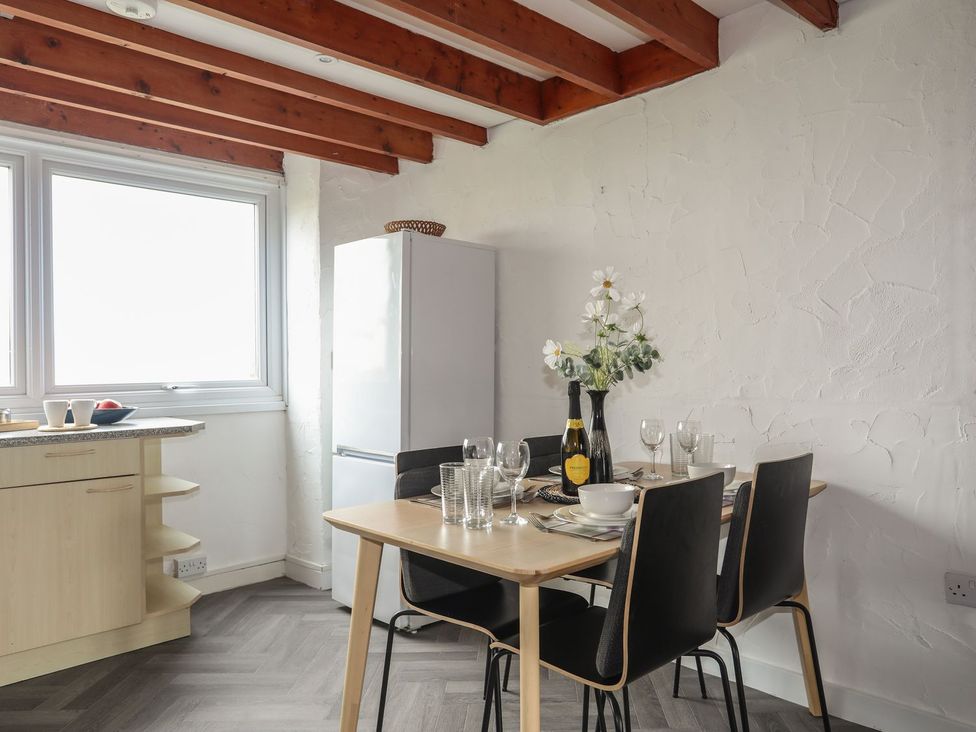 A kitchen with a dining table and chairs at Penrhyn - 4 Ty'n Don