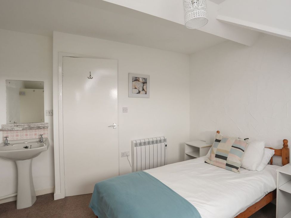 A bedroom with a bed and a sink at Penrhyn - 4 Ty'n Don