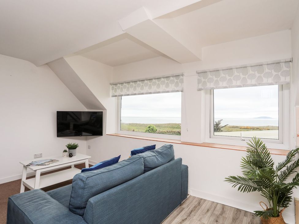 A living room with a sofa and television at Towyn - 7 Ty'n Don