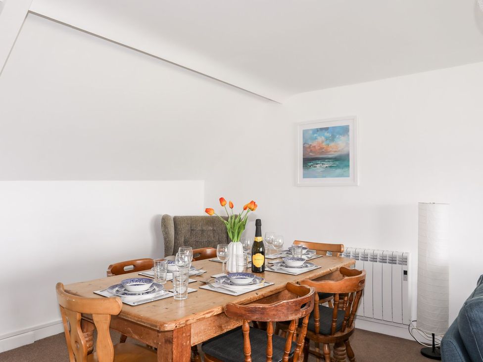 A dining room with a wooden table set for dining at Towyn - 7 Ty'n Don