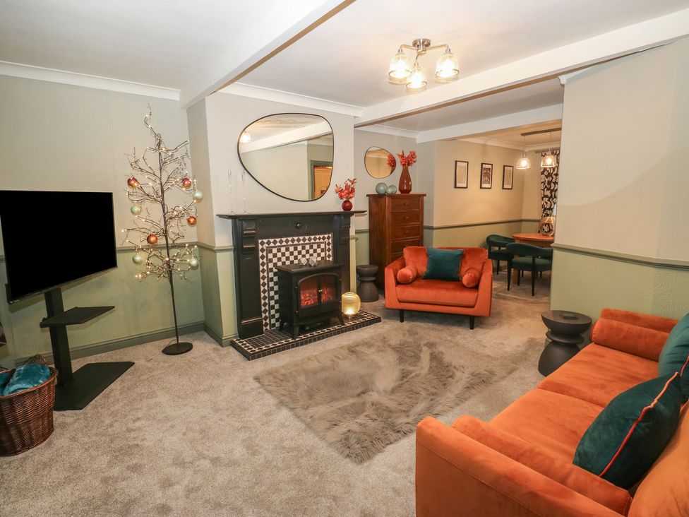 A living room with a fireplace and television at Franbols Cottage in Shelf