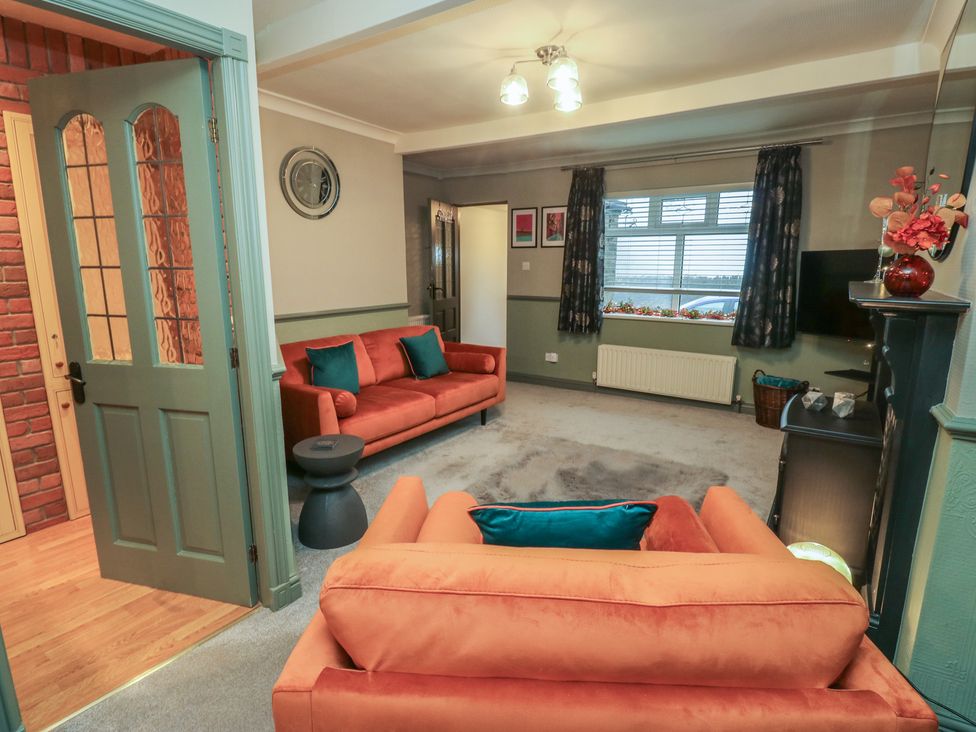 A living room with orange sofa and armchair at Franbols Cottage in Shelf
