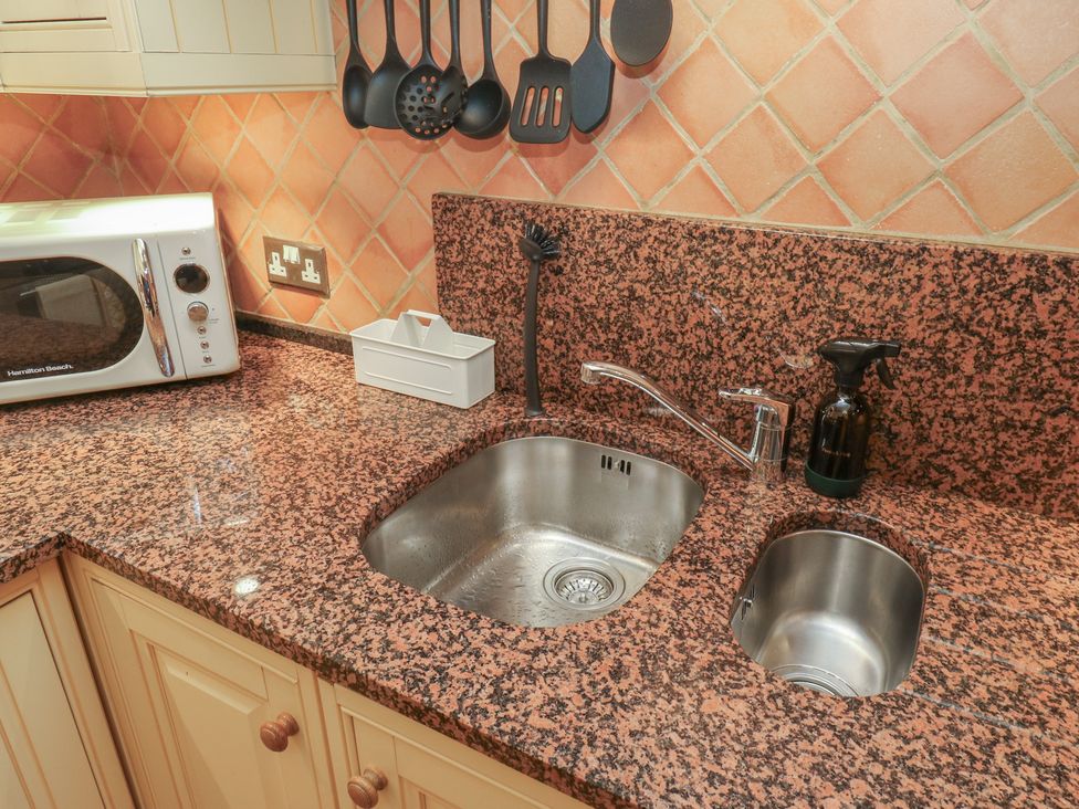 A kitchen with a sink and microwave at Franbols Cottage in Shelf